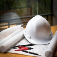 imgi_162_construction-concept-image-helmet-rolled-blueprints-wooden-boards-retro-style_1423-263